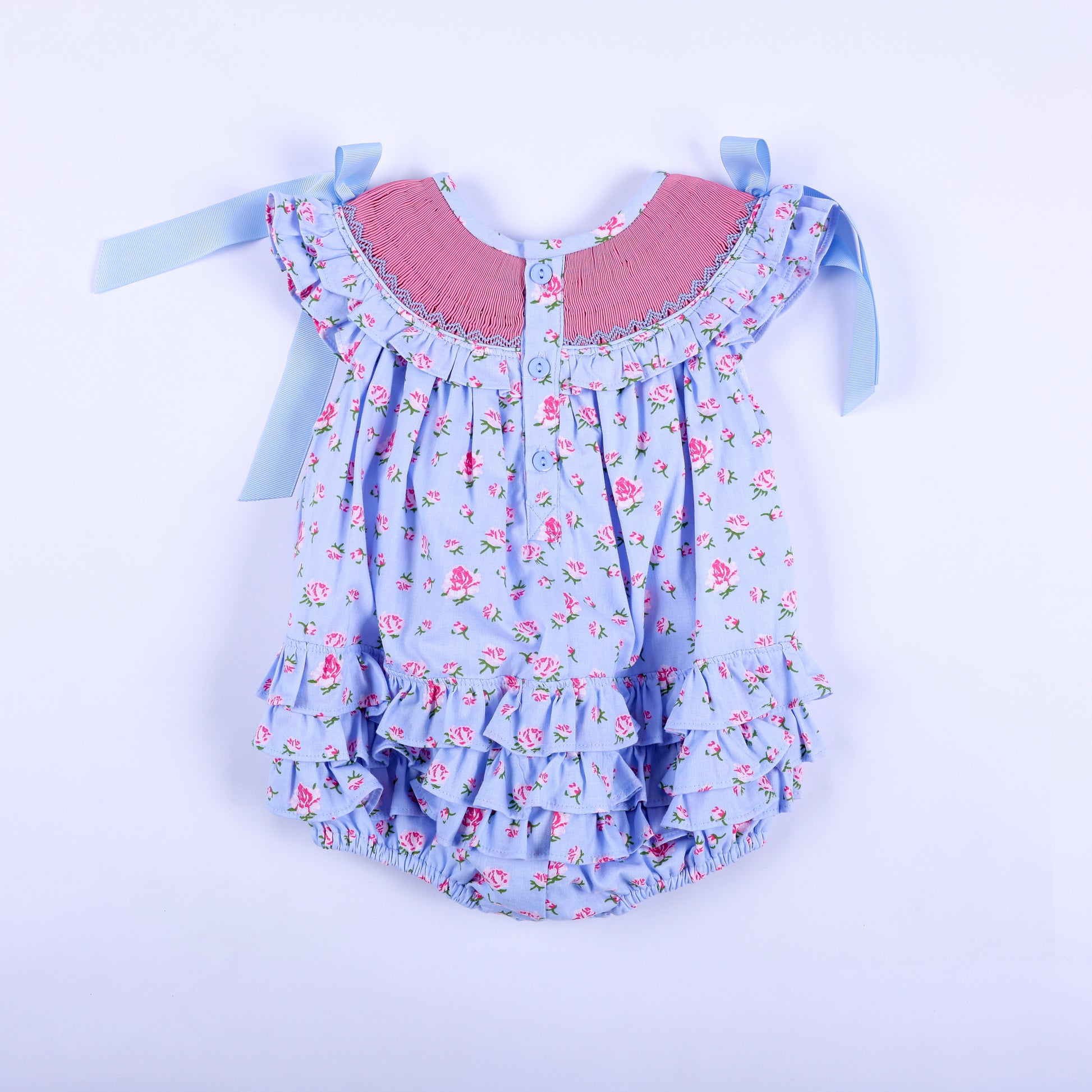 Back view of light blue floral hand smocked baby bubble with back button closures and tiered ruffles.