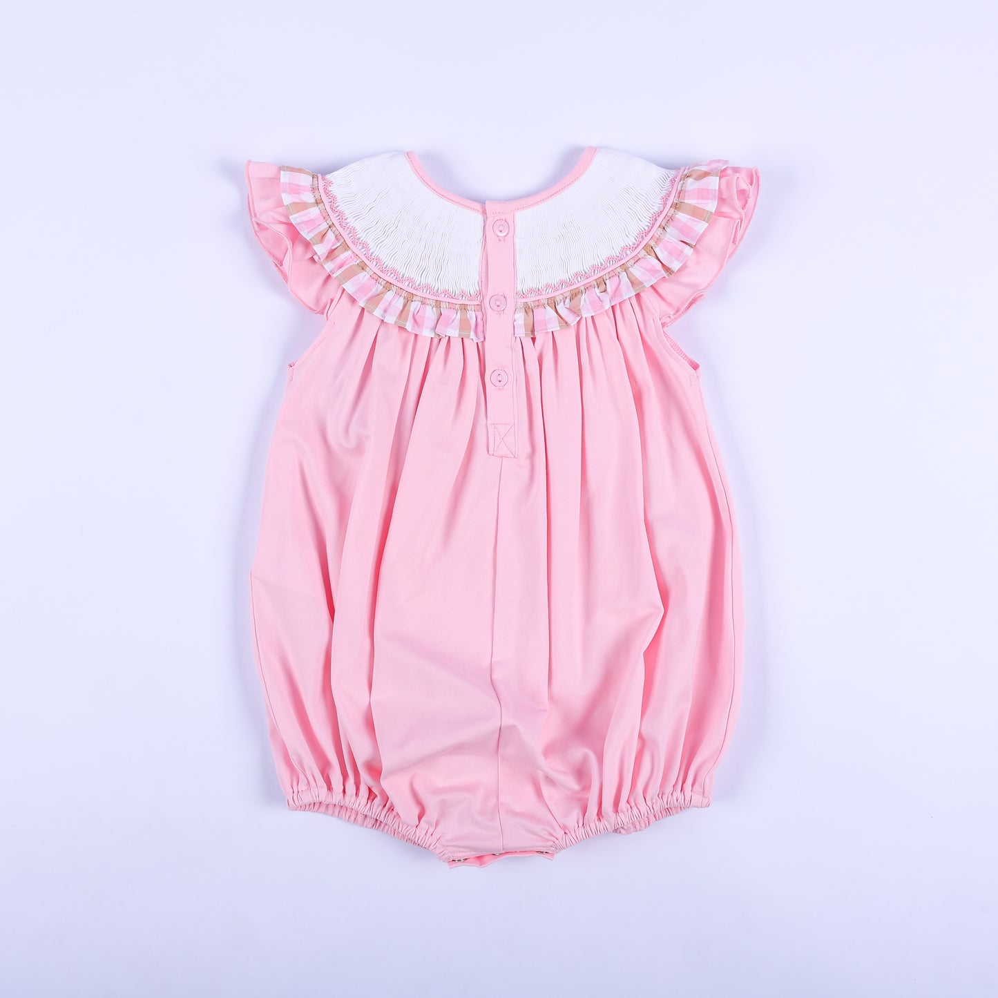 Full back view of a pink hand-smocked baby bubble outfit showing back button closure and ruffled flutter sleeves.