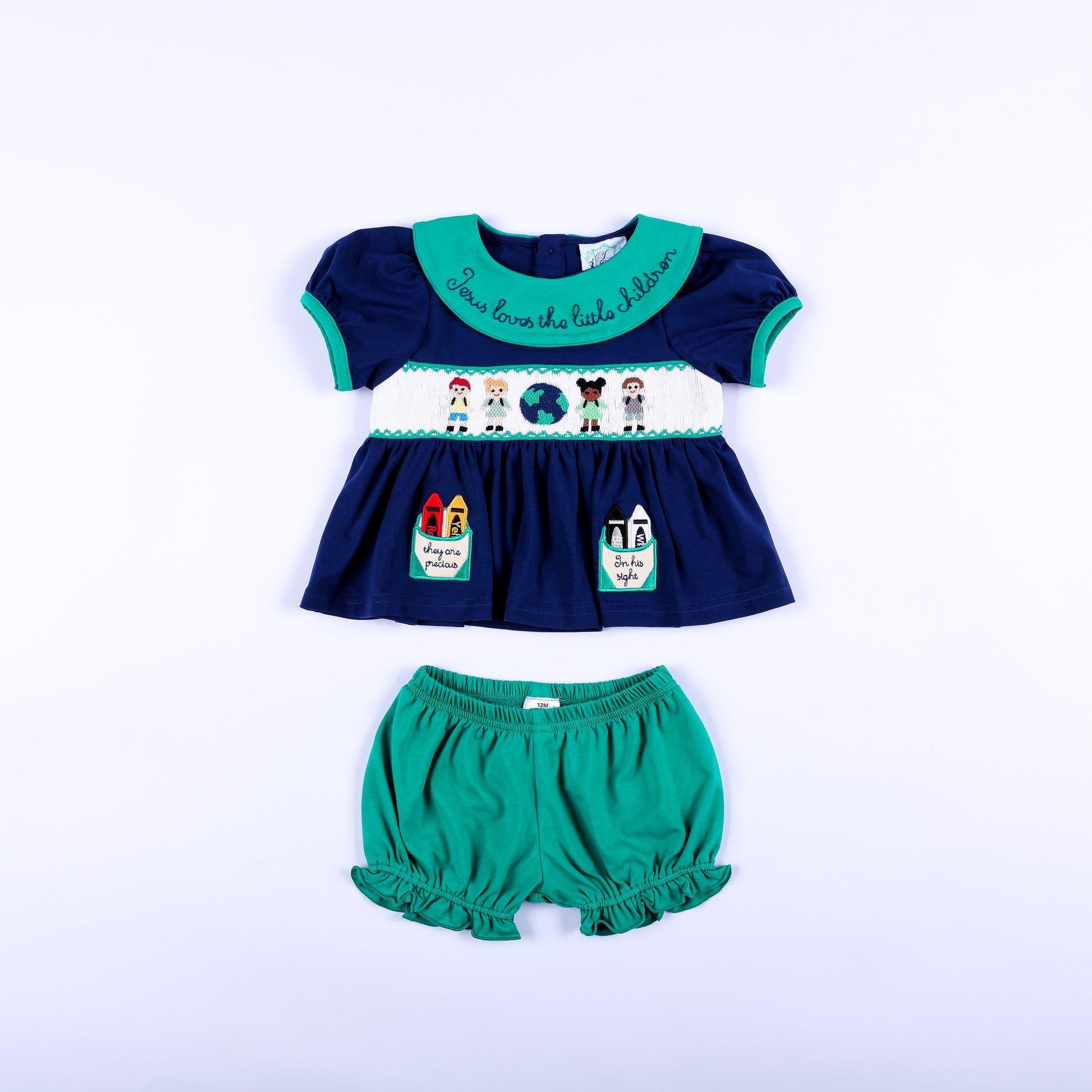 Full front view of Jesus Loves the Little Children navy hand smocked top and green ruffle bloomer set.