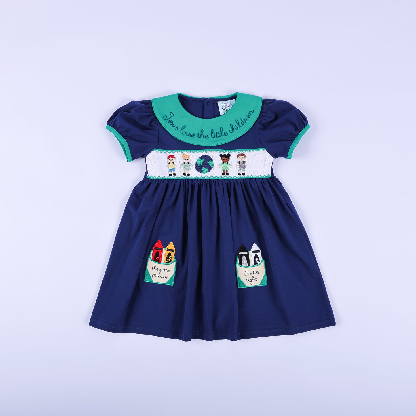 Navy hand-smocked dress with a 'Jesus Loves the Little Children' green embroidered collar and sweet crayon pockets.