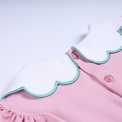 Back collar detail showing pink button closure on white scalloped Peter Pan collar with turquoise trim.
