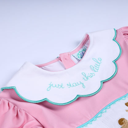 White scalloped collar close-up with turquoise trim and embroidered text Just Stay This Little phrase.