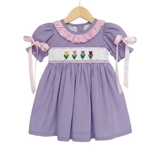 Lavender girls smocked dress with embroidered tulips, pink ruffled collar, and puff sleeves with bows for Easter.