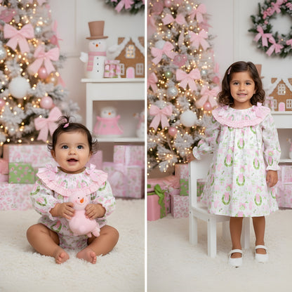 Matching sister girls Christmas watercolor smocked dress and baby bubble romper set by holiday tree.