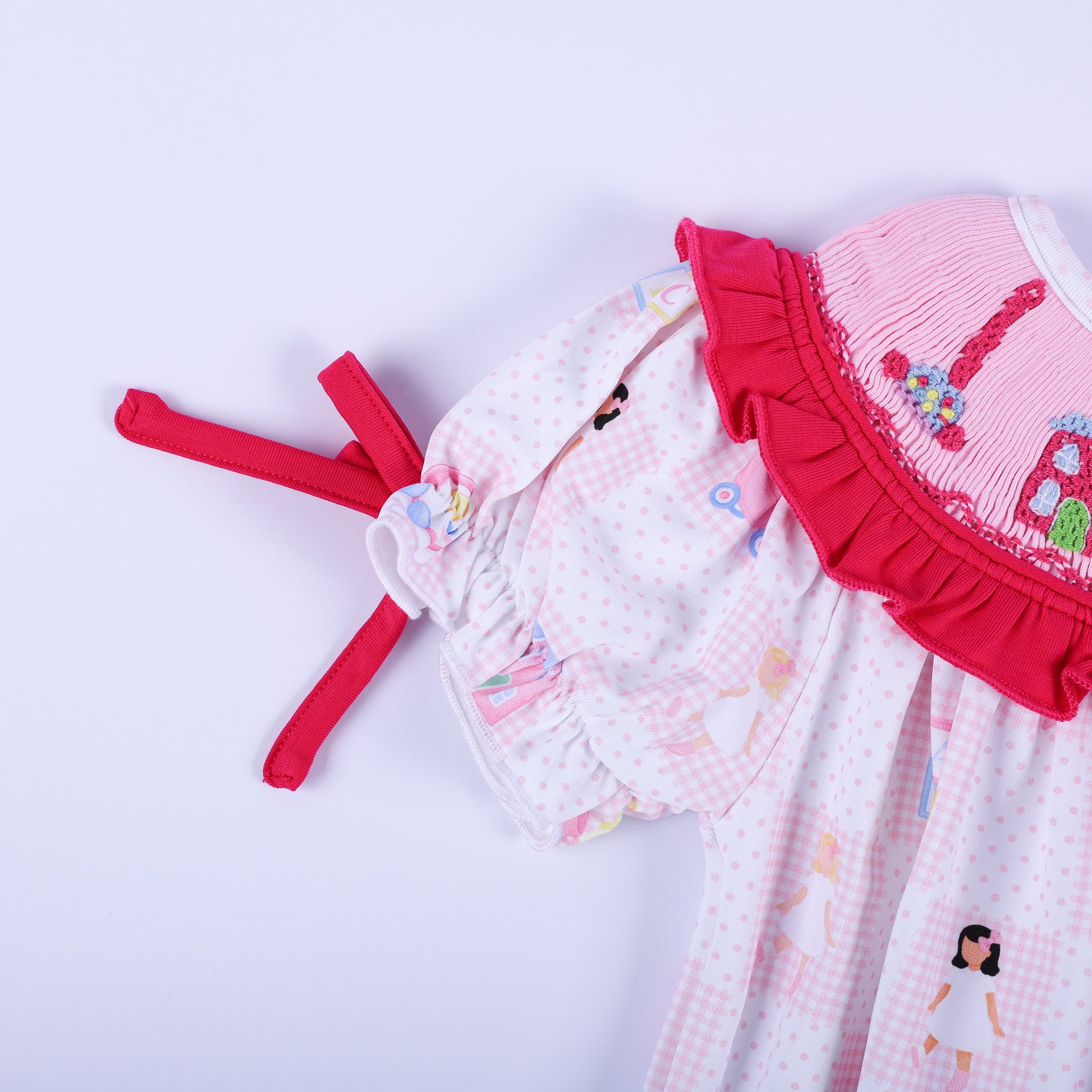 Detailed view of the short puffed sleeve with a hot pink bow and ruffle on the Dolly & Me infant bubble romper.