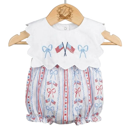 Patriotic Grandmillennial embroidered baby bubble on wooden hanger featuring scalloped collar with flag embroidery.
