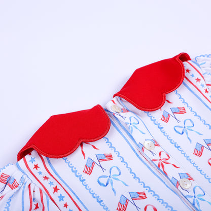 Close-up detail of back button closure and red scalloped collar on patriotic hand embroidered smocked baby bubble.