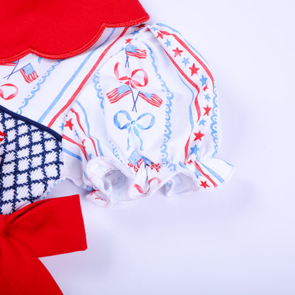 Detailed shot of puffed short sleeve with ruffles on America the Beautiful hand smocked patriotic baby girl bubble.