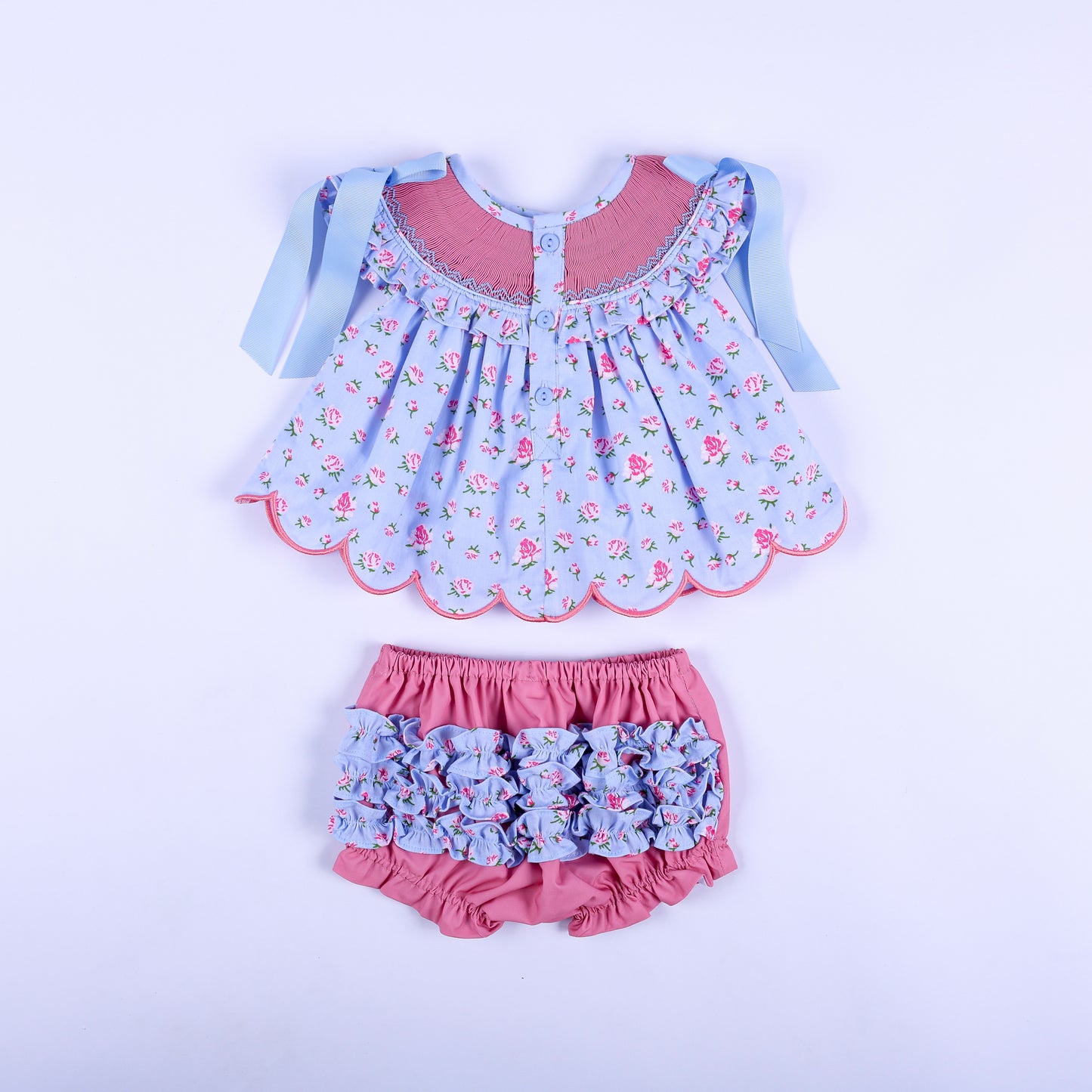 Detail view of ruffled elastic leg opening on soft solid pink diaper cover bloomer for baby girl outfits.