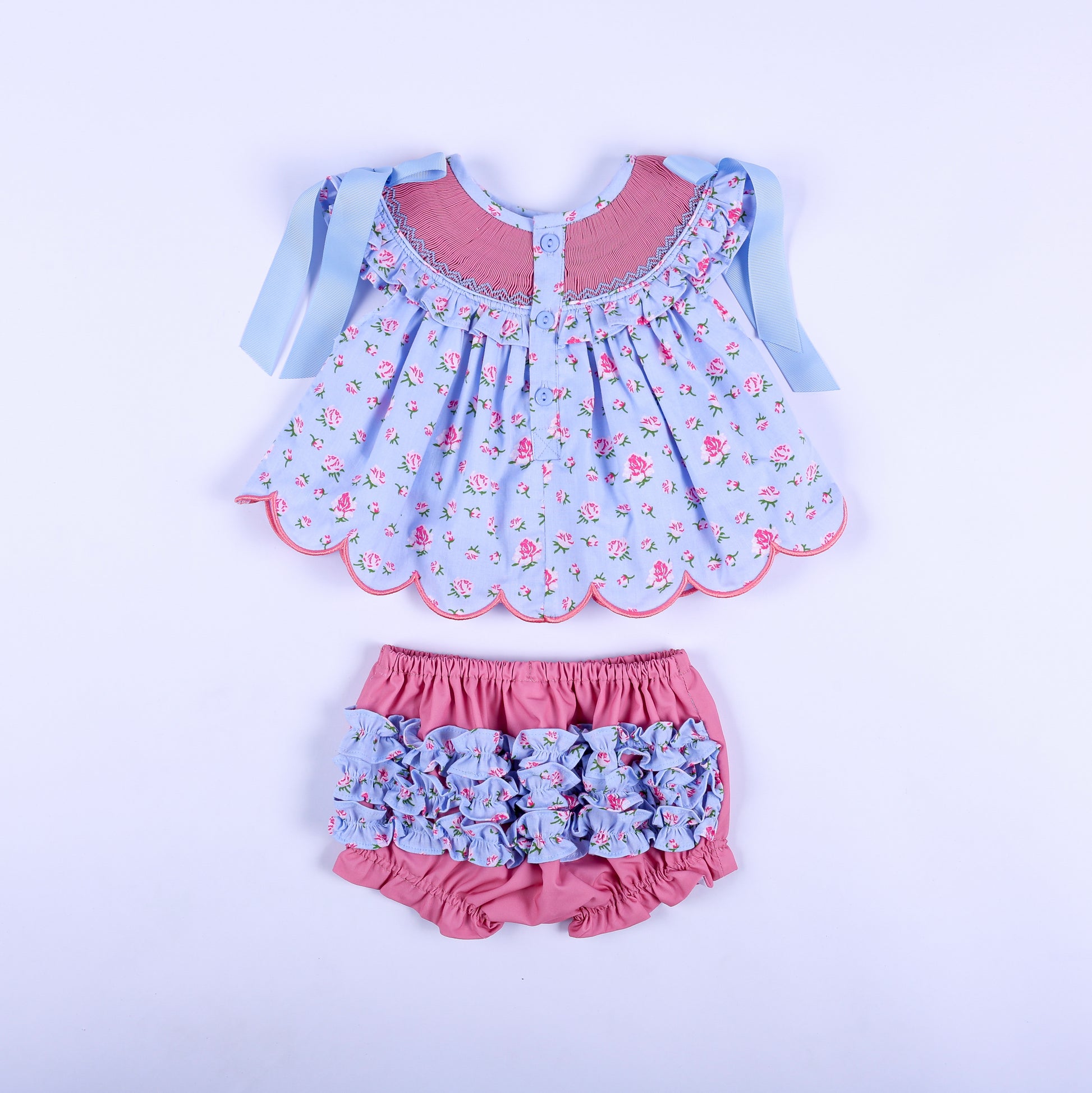 Detail view of ruffled elastic leg opening on soft solid pink diaper cover bloomer for baby girl outfits.