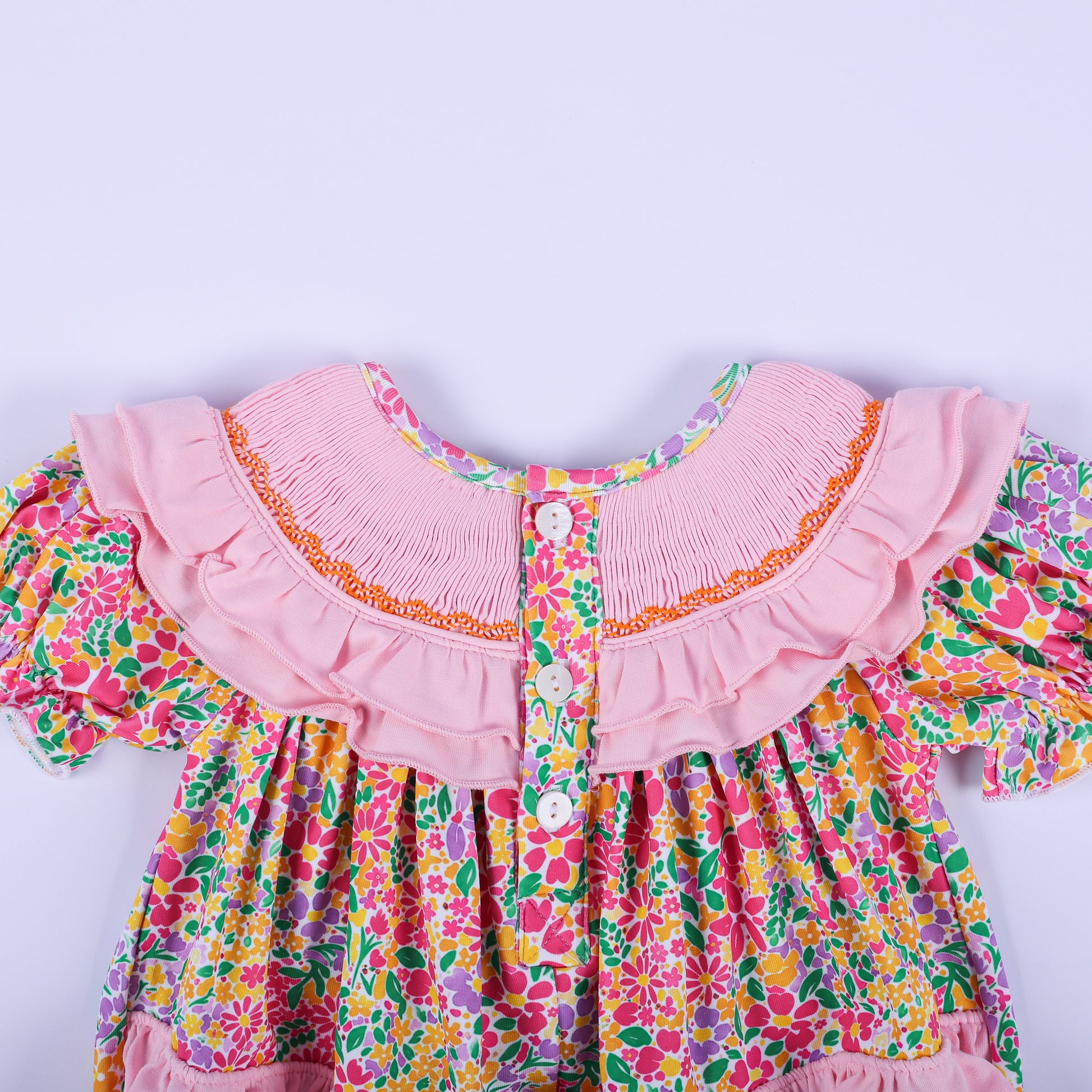 Back view of the pink floral Thanksgiving baby bubble romper, highlighting the button closures and smocked ruffled collar.