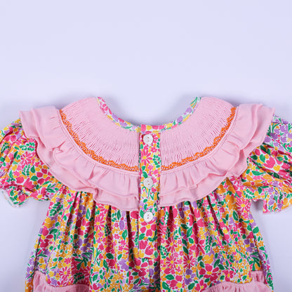 Back view of the pink floral Thanksgiving baby bubble romper, highlighting the button closures and smocked ruffled collar.