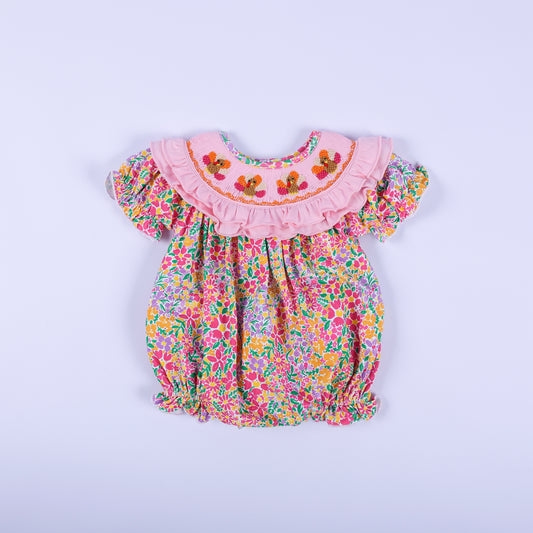 Pink floral Thanksgiving baby bubble romper with a smocked ruffled collar featuring three hand-embroidered turkeys.