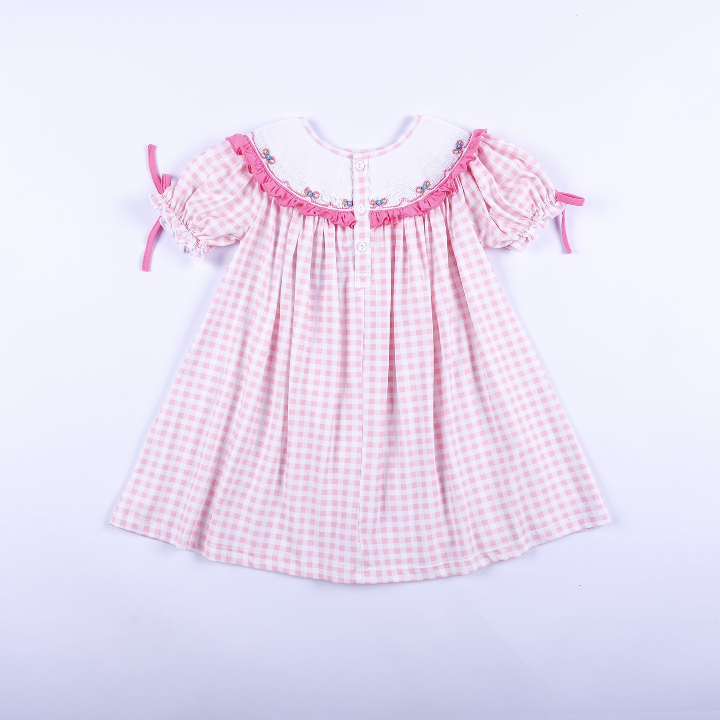 Full back view of pink gingham Big Sister hand-smocked dress showing back button closure and puff tie sleeves.