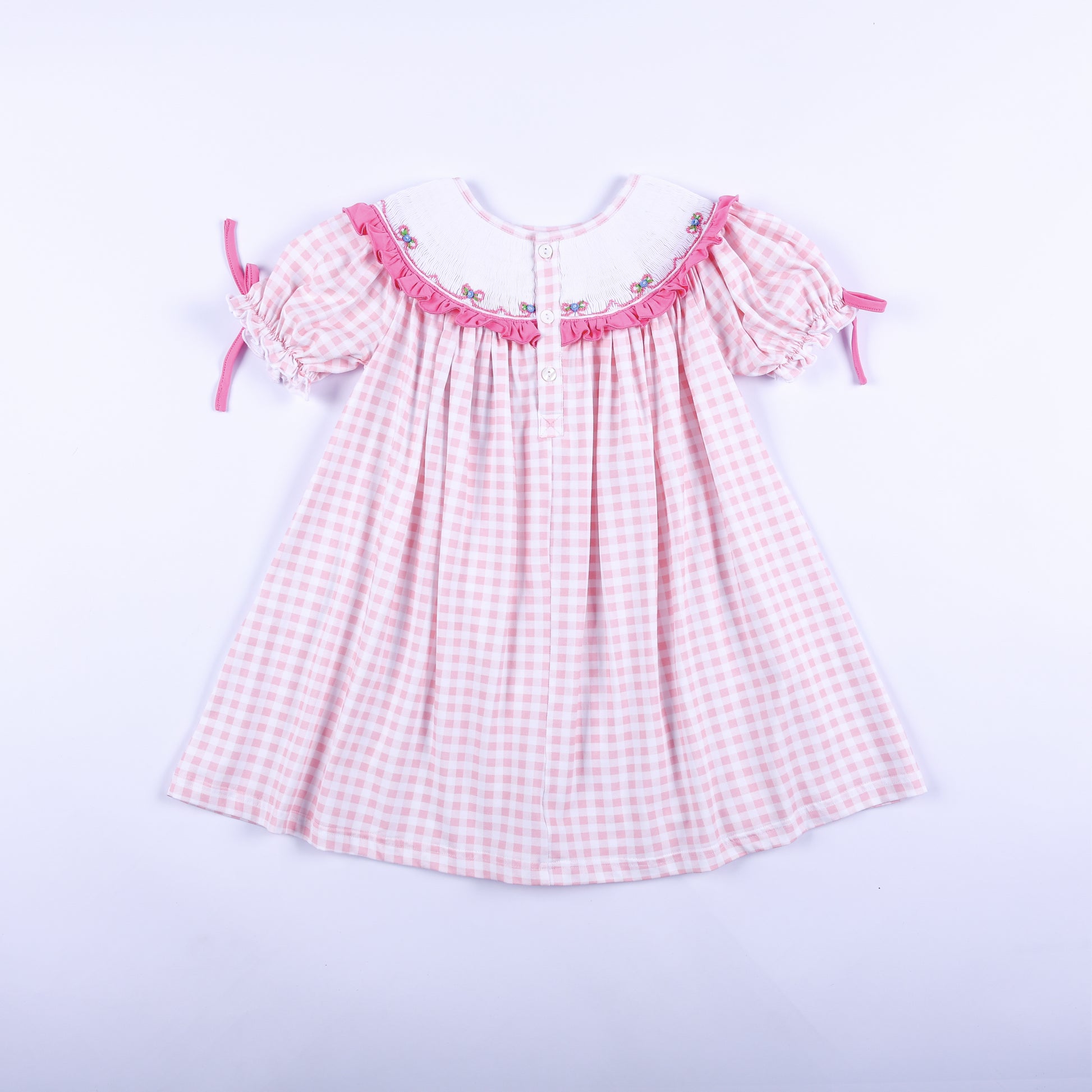 Full back view of pink gingham Big Sister hand-smocked dress showing back button closure and puff tie sleeves.