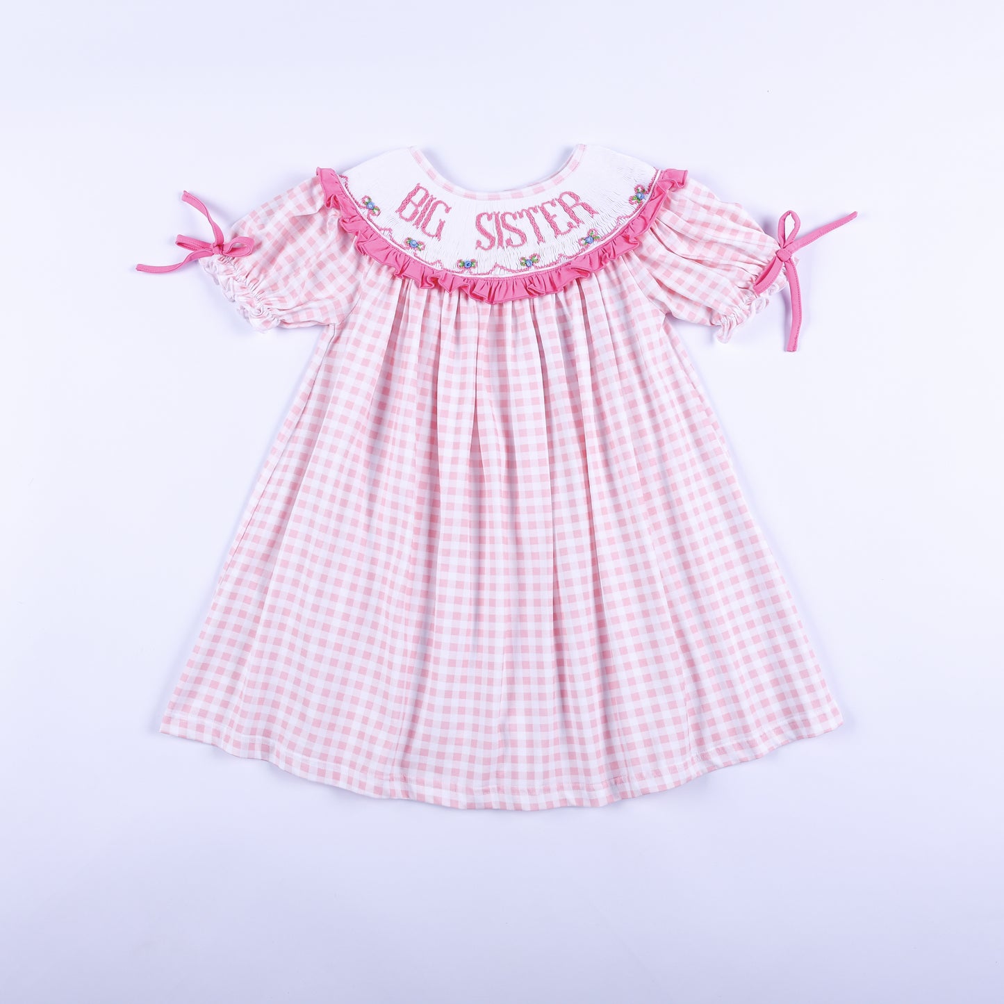 Front view of a pink gingham Big Sister dress with hand-smocked embroidered collar and ruffled puff sleeves.