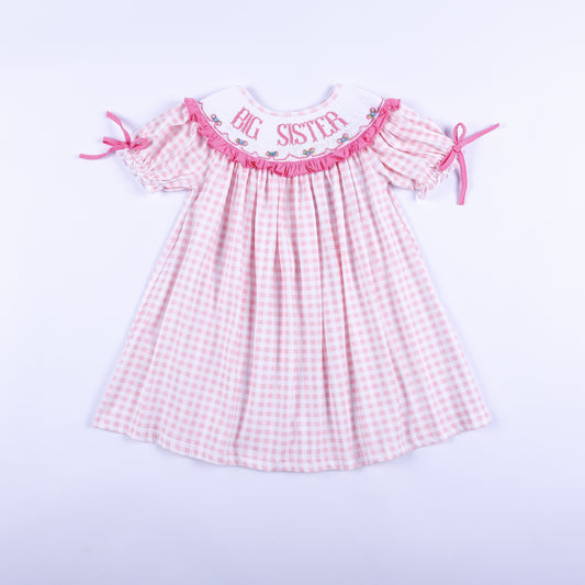 Front view of a pink gingham Big Sister dress with hand-smocked embroidered collar and ruffled puff sleeves.