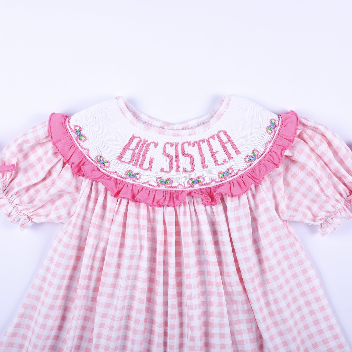Close up front view of hand smocked Big Sister embroidered white ruffle collar on pink gingham outfit.