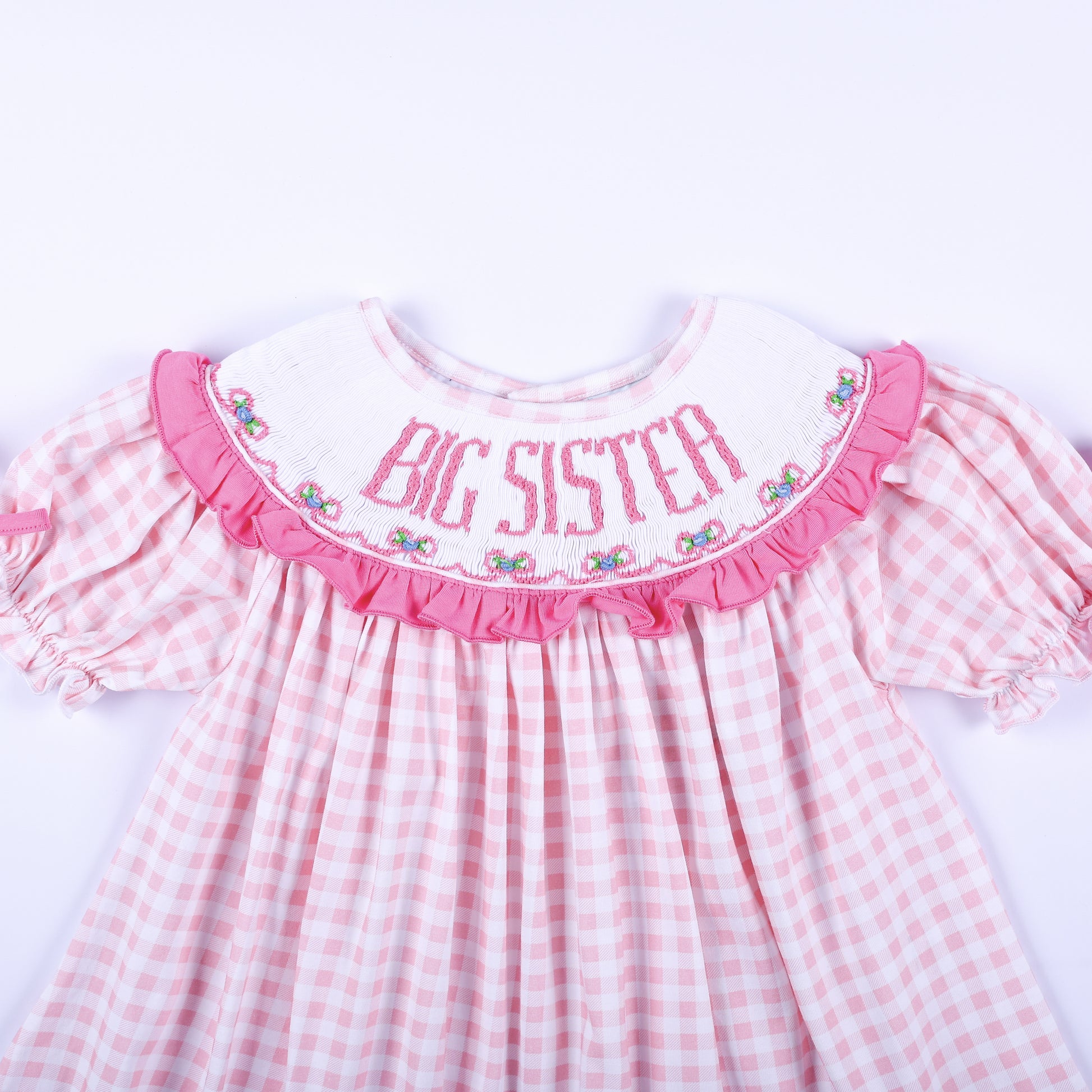 Close up front view of hand smocked Big Sister embroidered white ruffle collar on pink gingham outfit.