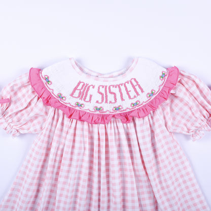 Close up front view of hand smocked Big Sister embroidered white ruffle collar on pink gingham outfit.