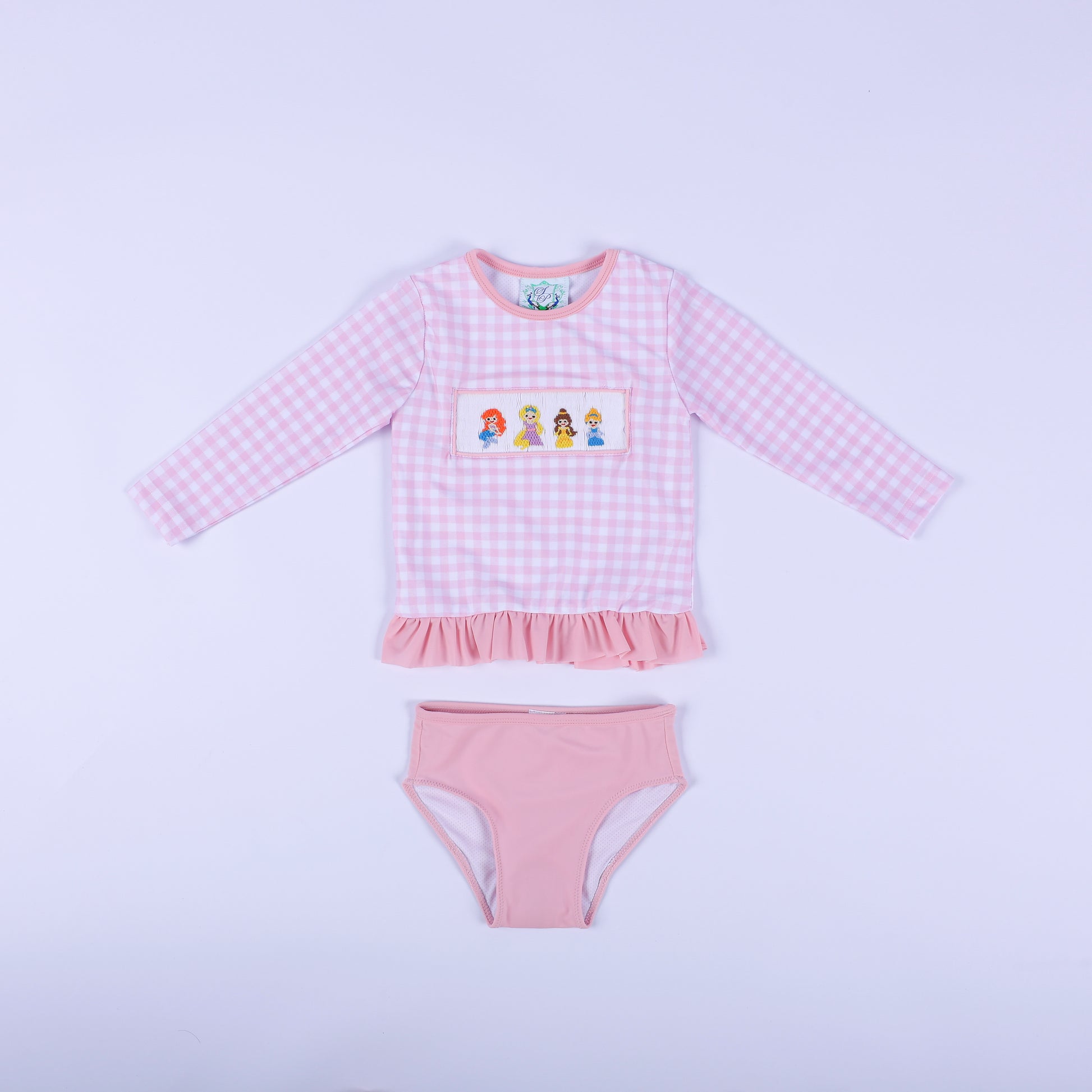 Front flat lay of girls pink gingham fairytale princess hand smocked two piece rash guard swimsuit with pink bottoms.
