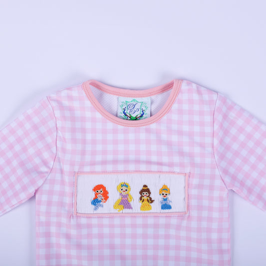 Close up of the girls pink gingham rash guard top neckline and hand smocked fairytale princess bodice embroidery.