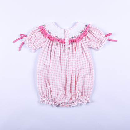 Full back view of baby girls pink gingham hand smocked Little Sister bubble romper showing button closures.