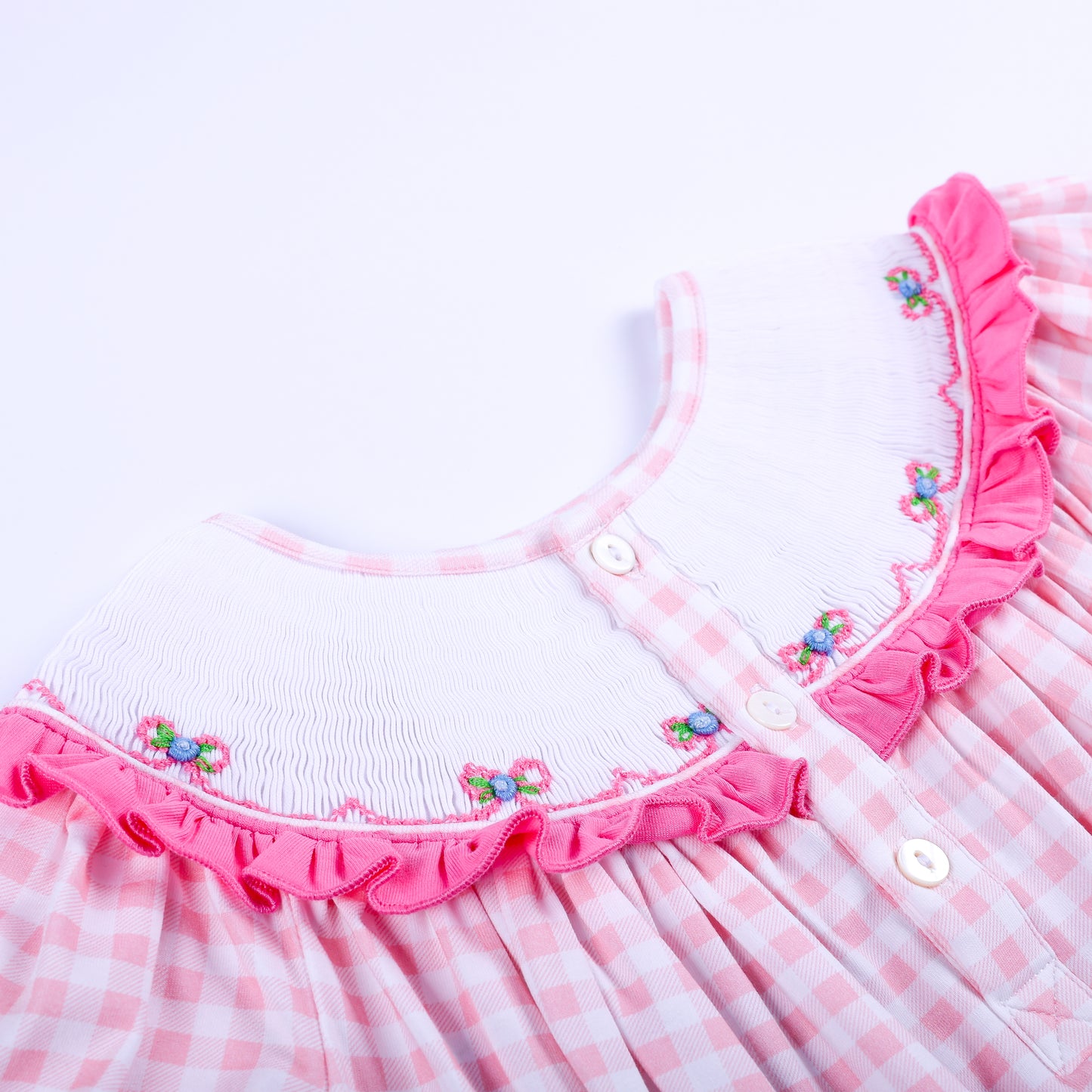 Back collar detail of pink gingham Big Sister smocked dress featuring white buttons and embroidered floral bows.