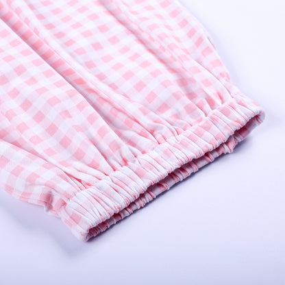 Close-up view of comfortable elastic bottom hem on pink gingham hand smocked Little Sister baby sleep sack.
