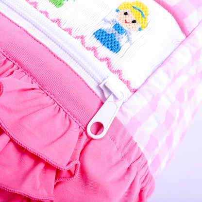 Close-up view of sturdy zipper pull on a pink gingham hand-smocked fairytale princess backpack for kids.