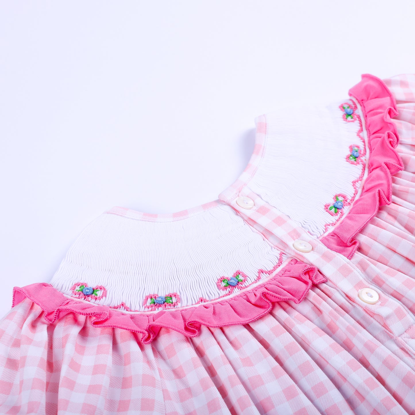 Close up back view of white button closures and smocked ruffle collar on pink gingham Big Sister dress.