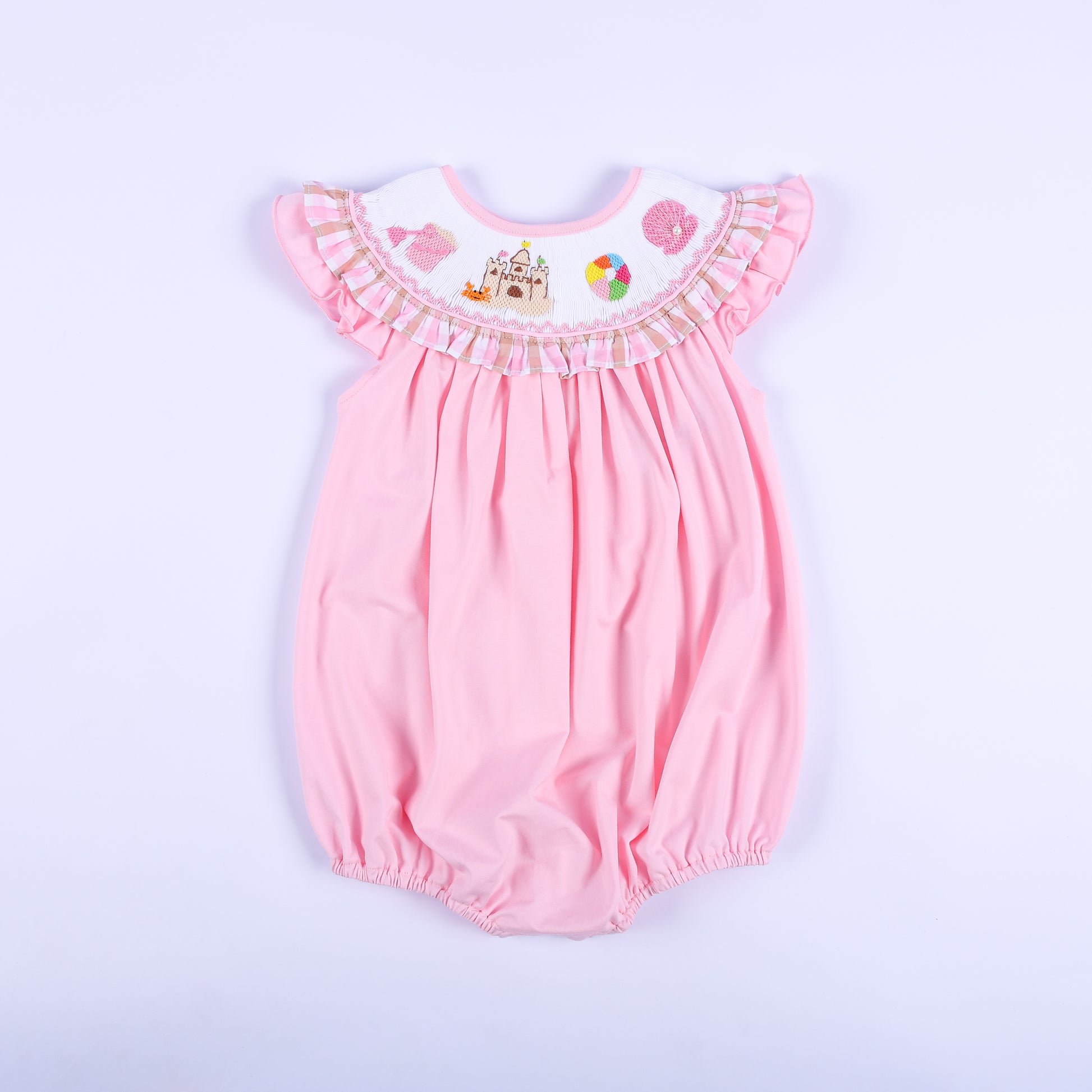 Front view of a pink hand-smocked baby bubble outfit featuring a ruffled beach-themed embroidered collar.