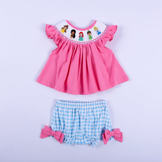 Pink princess hand-smocked knit top paired with blue gingham diaper cover bloomer set for baby girls.