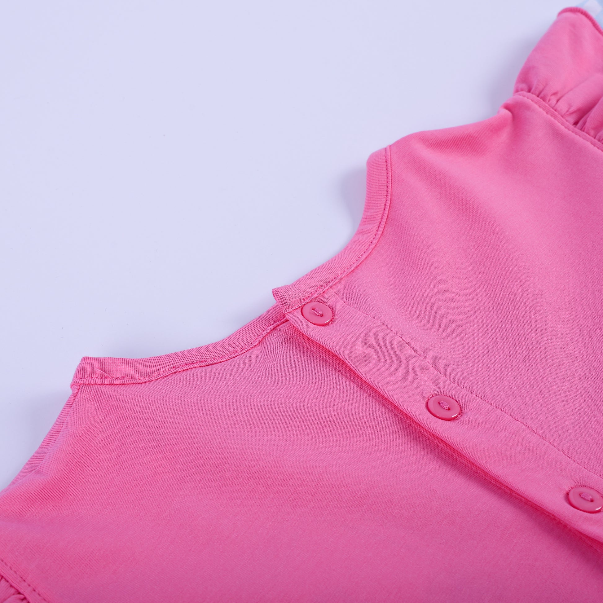 Full back view of girls pink princess knit hand smocked dress showing button closure and blue gingham ruffle hem.