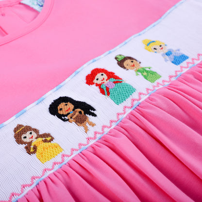 Angled close-up of hand smocked plate featuring hand embroidered princesses on pink knit dress with gathered skirt.