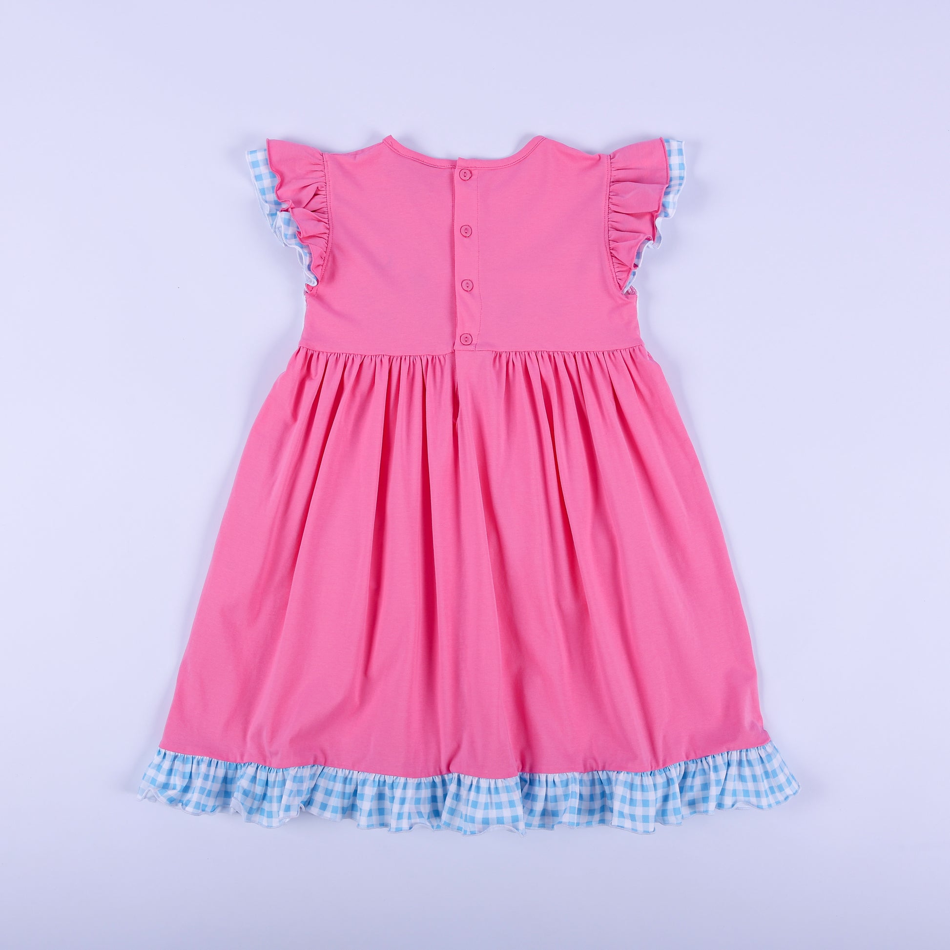 Detailed view of hand smocked plate with colorful hand embroidered princess figures on pink girls knit dress.