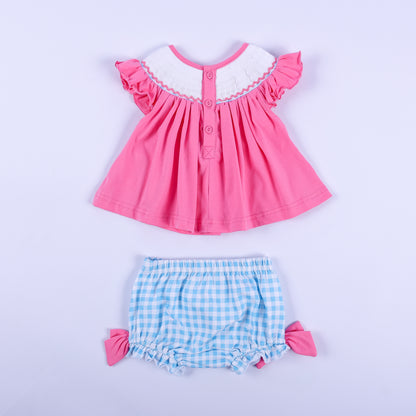 Back view of pink knit hand-smocked top with button closure and blue gingham bloomer set for baby girls.