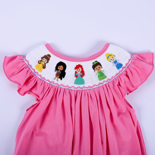 Close-up of hand-embroidered princess figures on a white hand-smocked collar on a pink baby knit bubble romper.