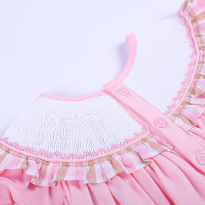 Close-up of back button closure on a pink hand-smocked baby bubble collar with pink gingham ruffle edging.