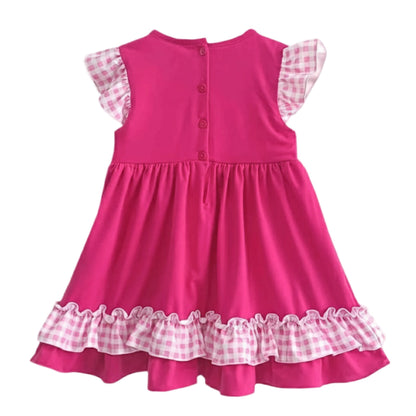 Back view of a hand smocked pink princess dress with buttons and pink gingham ruffles on the sleeves and hem.