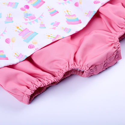 Close-up of pink bloomer bottom with convenient snap buttons on a baby girl birthday smocked bubble outfit.
