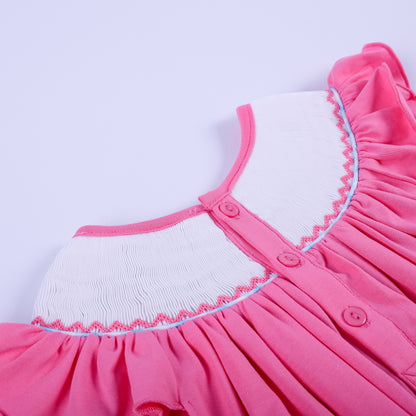 Detailed back close-up showing pink buttons and delicate smocked neckline stitching on a baby girl knit bubble outfit.