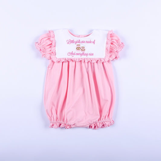 Pink embroidered baby girl bubble romper with white ruffled bib collar reading sugar and spice and everything nice.