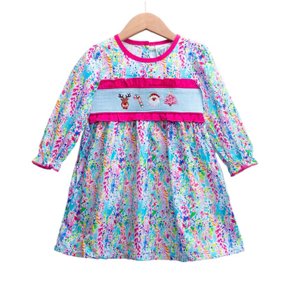 Girls pink tropical smocked dress with embroidered Santa, reindeer, candy cane, and Christmas tree. Blue and pink floral print.
