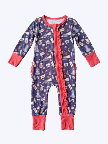 Navy Polar Express themed baby zip sleeper with coral ruffled trim flat lay on neutral textured backdrop   