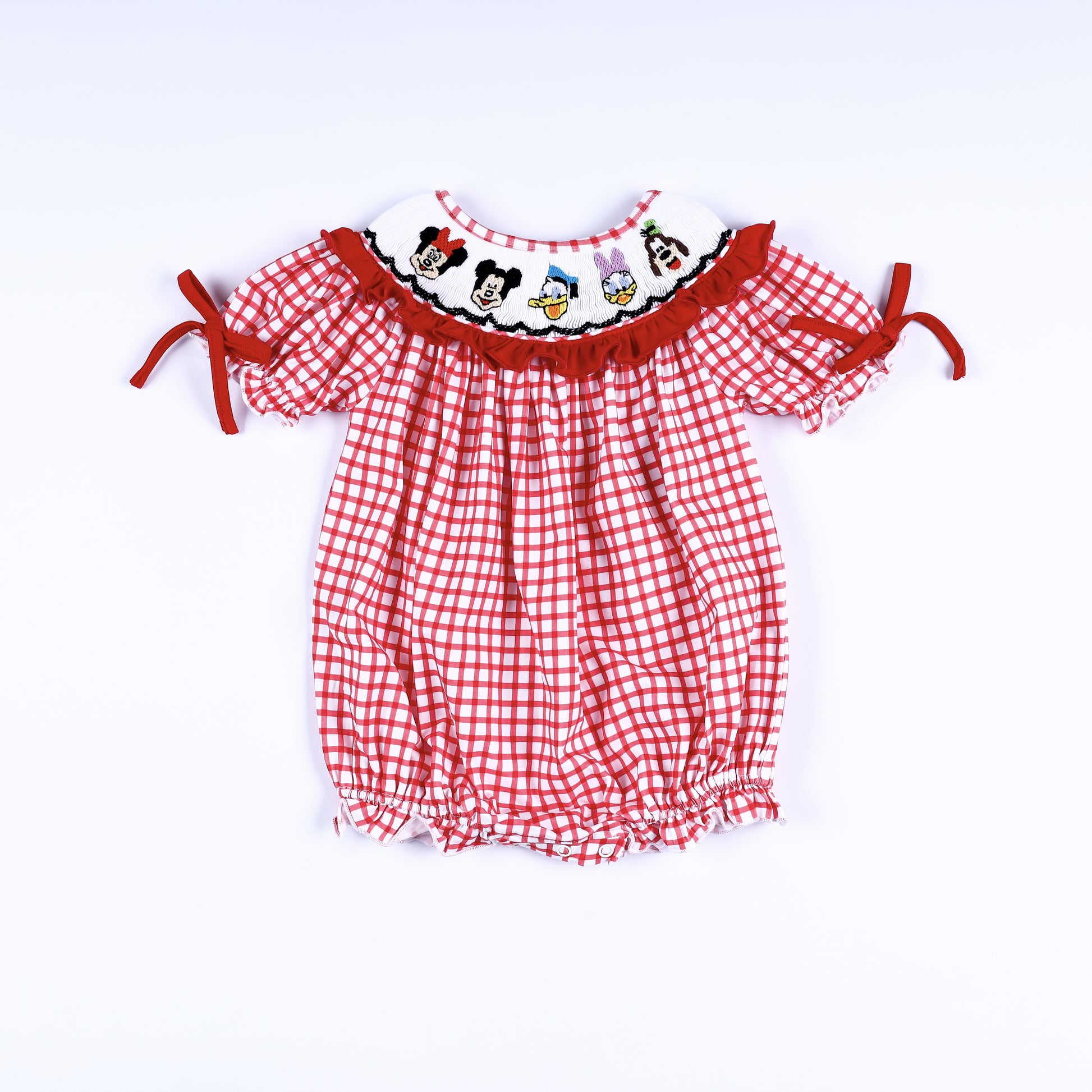 Full front view of a red gingham hand-smocked baby bubble outfit featuring embroidered cartoon character collar.