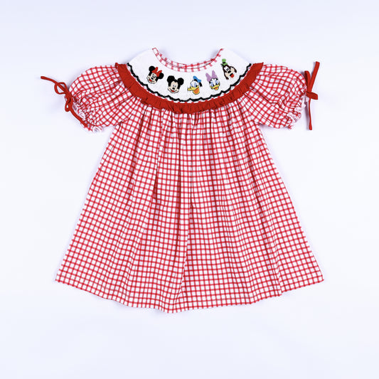 Front view of red gingham hand smocked dress for girls featuring colorful character embroidery and puff sleeves.