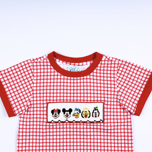 Close up view of the red crew neck collar and hand smocked cartoon character panel on a red gingham boys shirt.