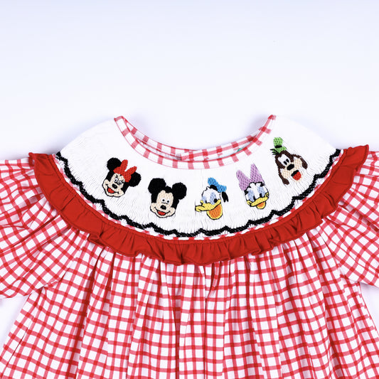Detailed view of hand embroidered cartoon character figures on a white smocked collar with red ruffle edging.