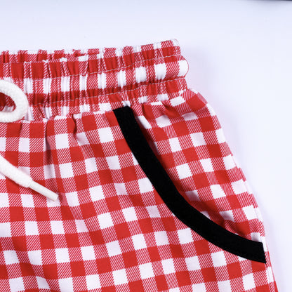 Detailed view of side pocket with black contrast trim on boys red gingham hand smocked shorts set bottom.